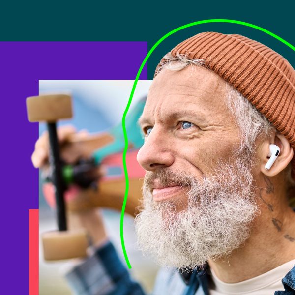 Person with grey hair and beard wearing a skateboard on his shoulders.