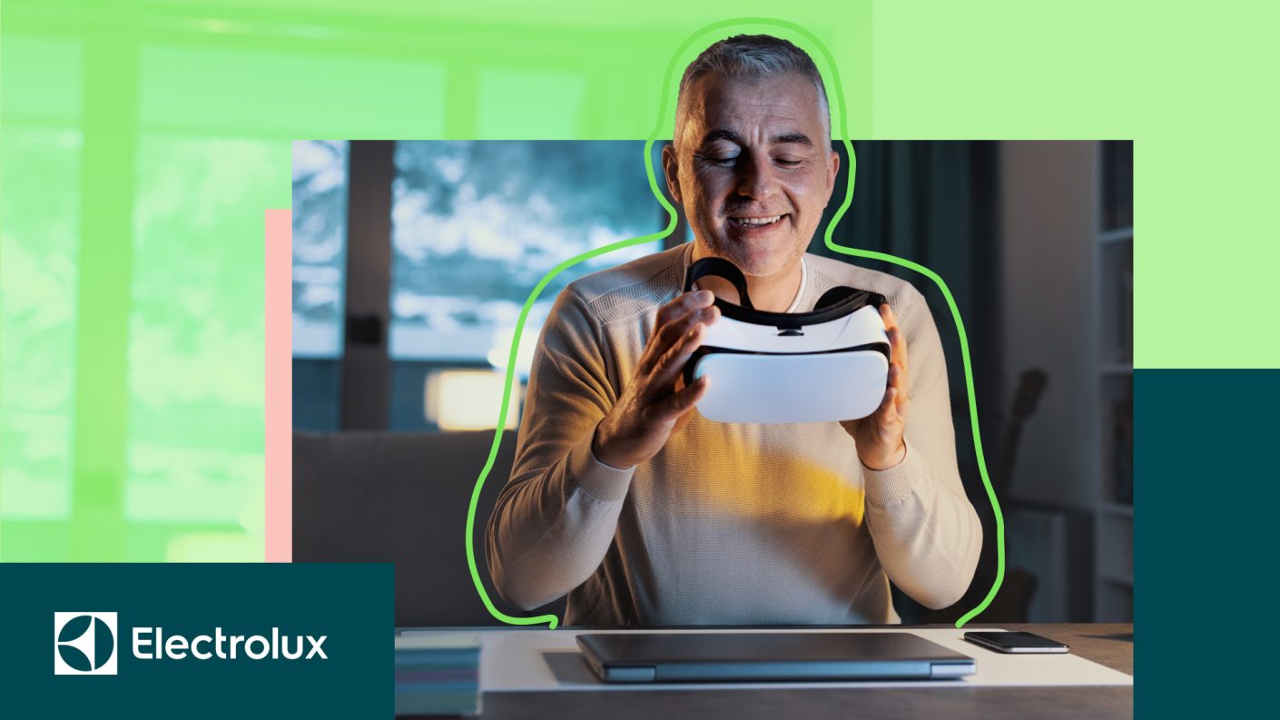 A person holidng a Virtual Reality headset and smiling